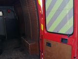 a red van with its door open in a parking lot
