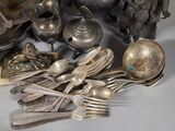 a lot of silver spoons and forks on the table