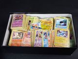 une boîte remplie de cartes Pokémon posée sur une table