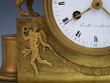 a gold clock with a statue of a man and a dog on it