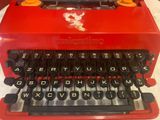 a red typewriter that is sitting on a table