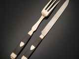 two forks and a knife on a table with a black background
