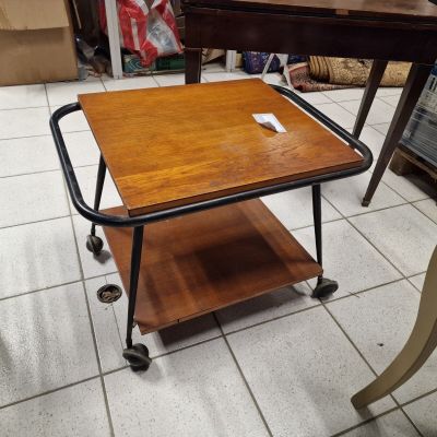 a table with a wooden top on wheels in a room
