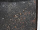 a piece of metal with rust on it on a white surface