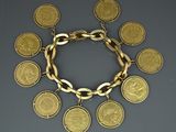 a close up of a gold bracelet with coins on it