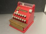 a red and gold typewriter sitting on a table