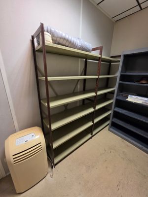 un petit climatiseur posé à côté d'une bibliothèque