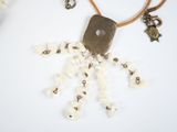 a necklace made of shells and beads on a white surface