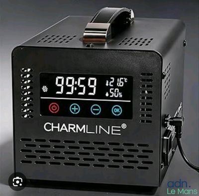 un réveil posé sur une table noire, à côté d'un chargeur