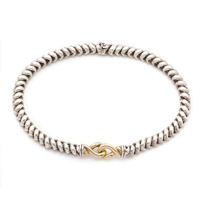 a silver and gold bracelet with a knot clasp