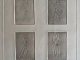 drawings of four different characters in a white frame on a wall