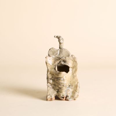 une petite statue représentant un éléphant sur laquelle est perché un oiseau