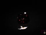 a close up of a red diamond on a black surface
