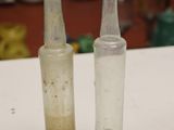 two empty glass bottles sitting on a white table