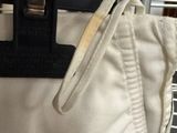 a white bag with a black handle hanging on a rack
