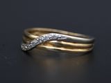 a close up of two gold rings with diamonds on a black surface