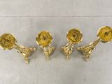 three gold candlesticks on a white table with a white background