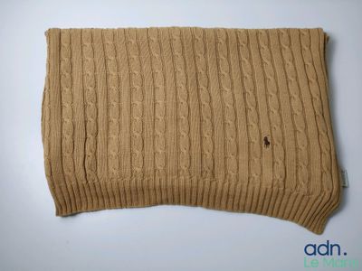 a close up of a knitted scarf on a white surface