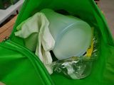 a green bag with a plastic container inside of it