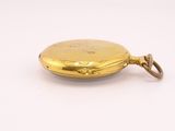 an antique gold pocket watch with a chain hanging from it ' s side