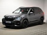 the bmw x5 is parked in a garage with a checkered floor