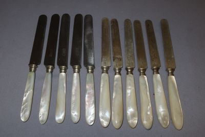 six knives are lined up in a row on a table