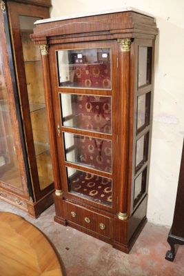 a wooden cabinet with a glass door and a clock on it