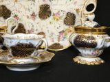 a tea set that is sitting on a black table