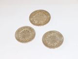 three coins sitting on top of each other on a white surface