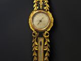une image représentant une horloge accrochée au mur, sur fond noir