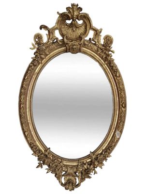 un miroir ovale doré dont le pourtour est orné d'un motif élaboré
