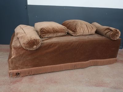 un canapé marron avec trois coussins dessus, dans une pièce