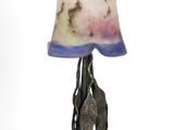a lamp that is sitting on a stand with a lamp shade on it