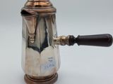 une cafetière ancienne en argent avec une poignée en bois sur fond blanc