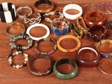 many different types of bracelets and rings on the table
