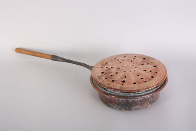 strainer with wooden handle on a white surface