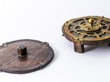 two small metal objects sitting on a white surface