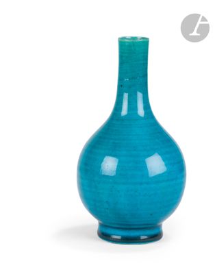 un vase bleu posé sur une surface blanche