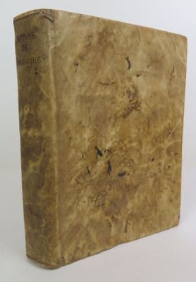 un vieux livre posé sur une table blanche à côté d'un mur blanc