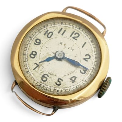 une horloge dorée posée sur une surface blanche