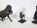 three bronze figurines of a horse, a man, and a deer