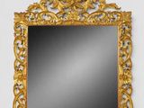 a gold framed mirror on a white wall next to a white wall