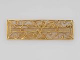 a gold plated brooche with a design of flowers and leaves