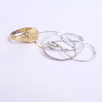 une bague en or et une bague en argent sur un fond blanc