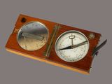 a wooden box with a clock and a compass on it