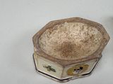 a small bowl sitting on a table with a flower decoration on it