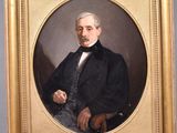 portrait of a man in a black coat holding a cane in a gold frame