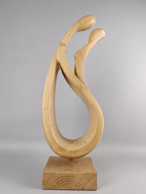 sculpture en bois représentant un oiseau, posée sur un socle en bois, sur fond gris
