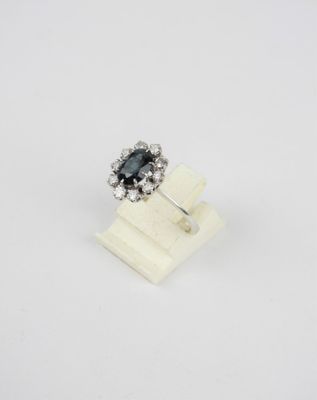 une bague en diamant noir et blanc posée sur un socle en marbre blanc