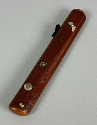 a small wooden pipe with flowers on it on a white surface
